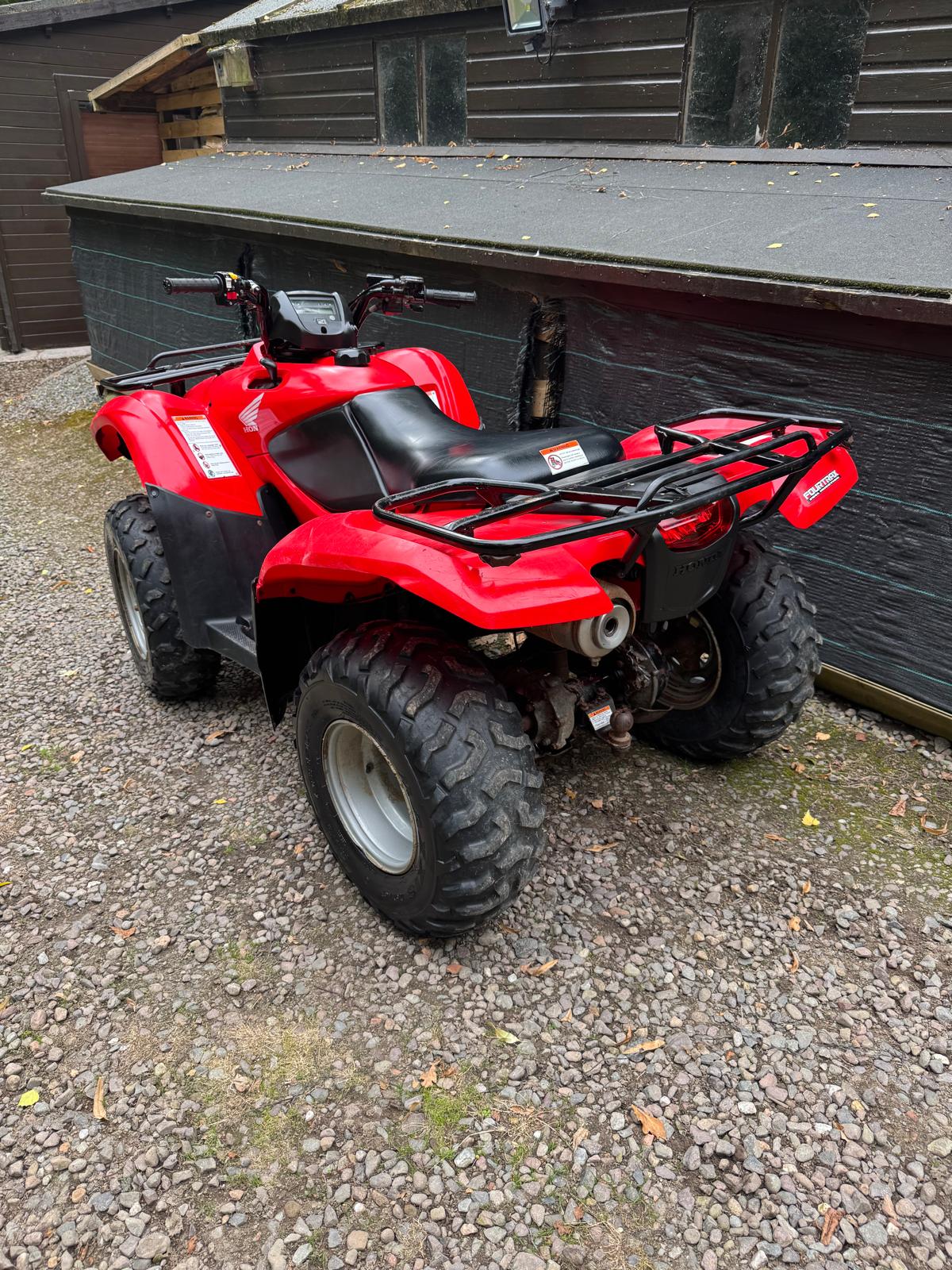 Red Honda Fourtrax quad bike, rear view